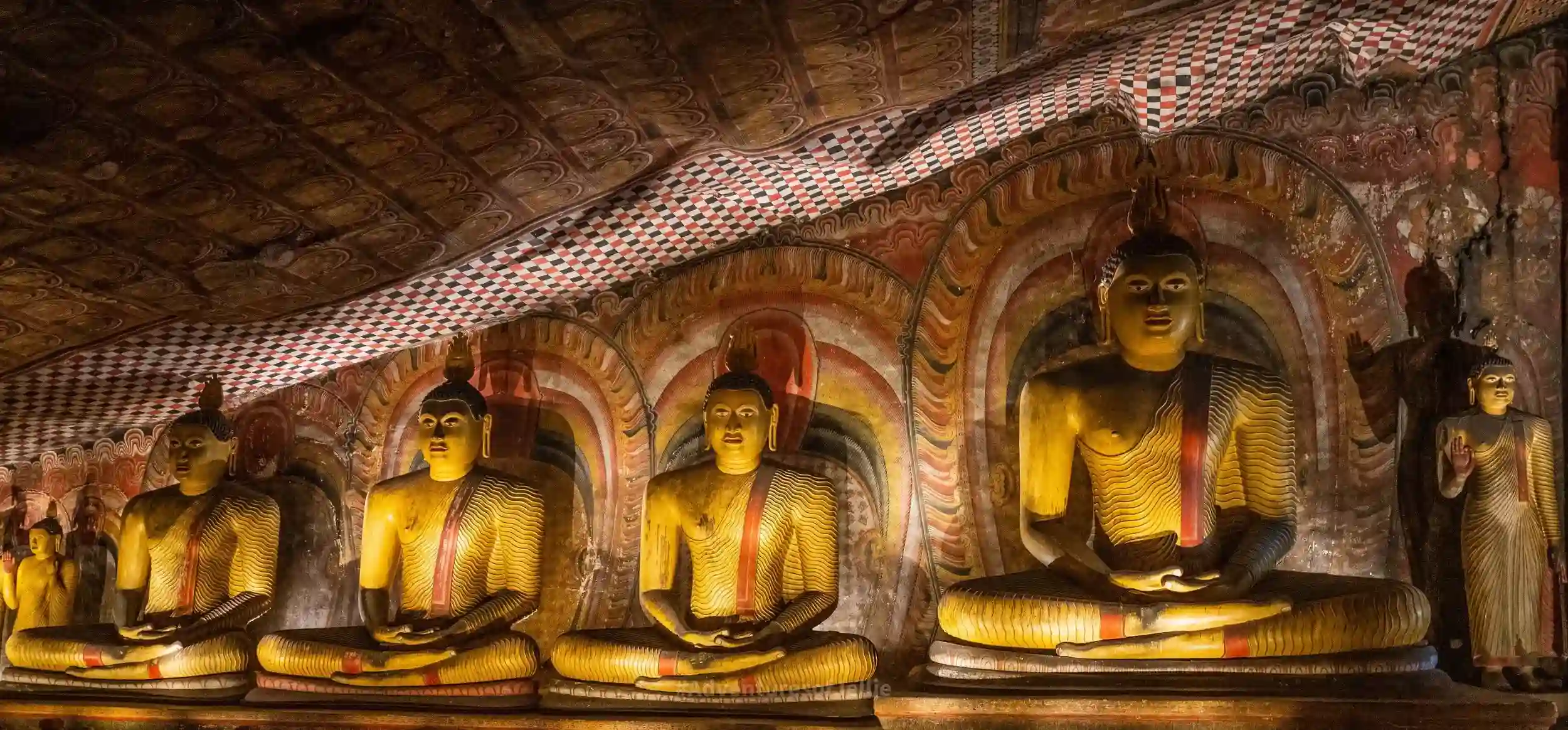 Interior of a Dambulla cave showing Buddha statues and murals